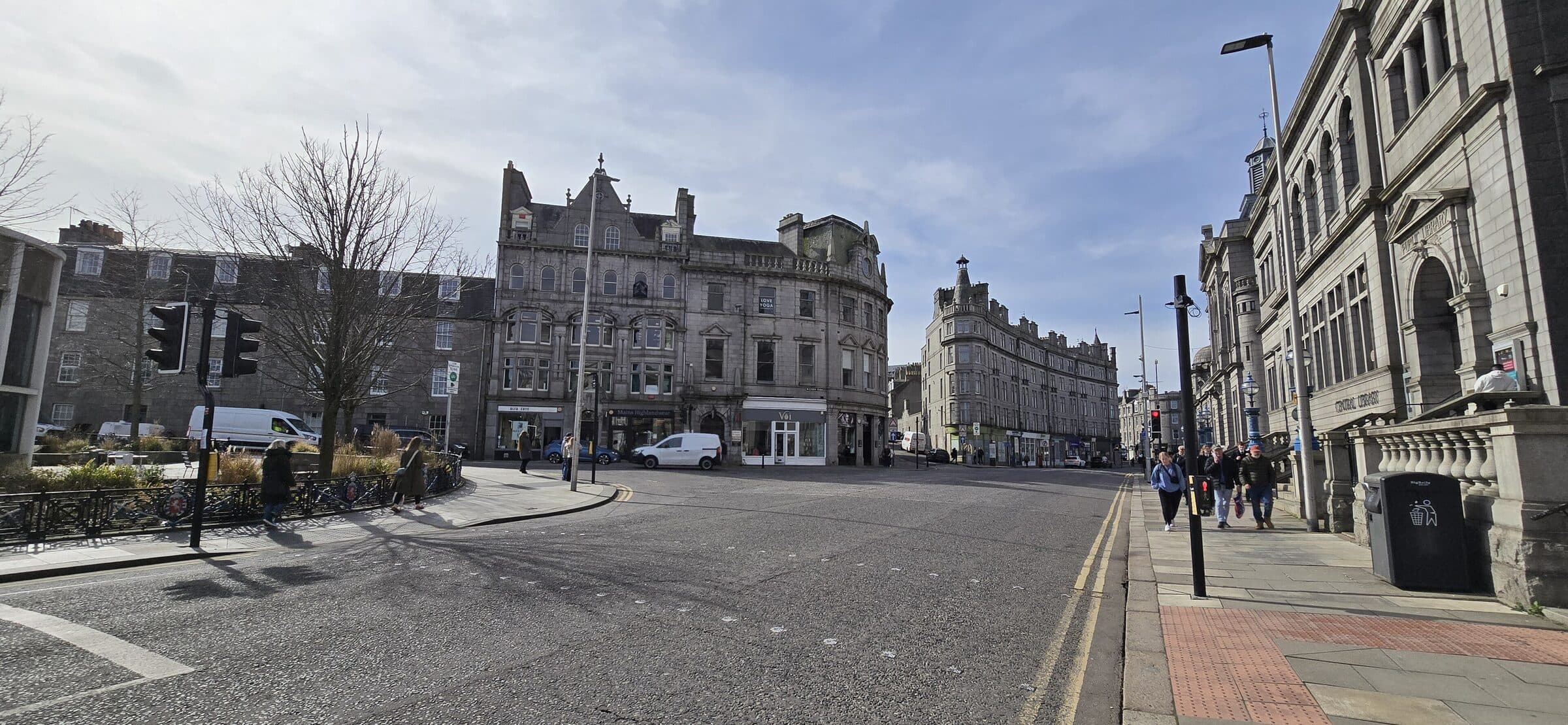 Granite tenements and Aberdeen Central Library on Union Terrace, with people walking past.